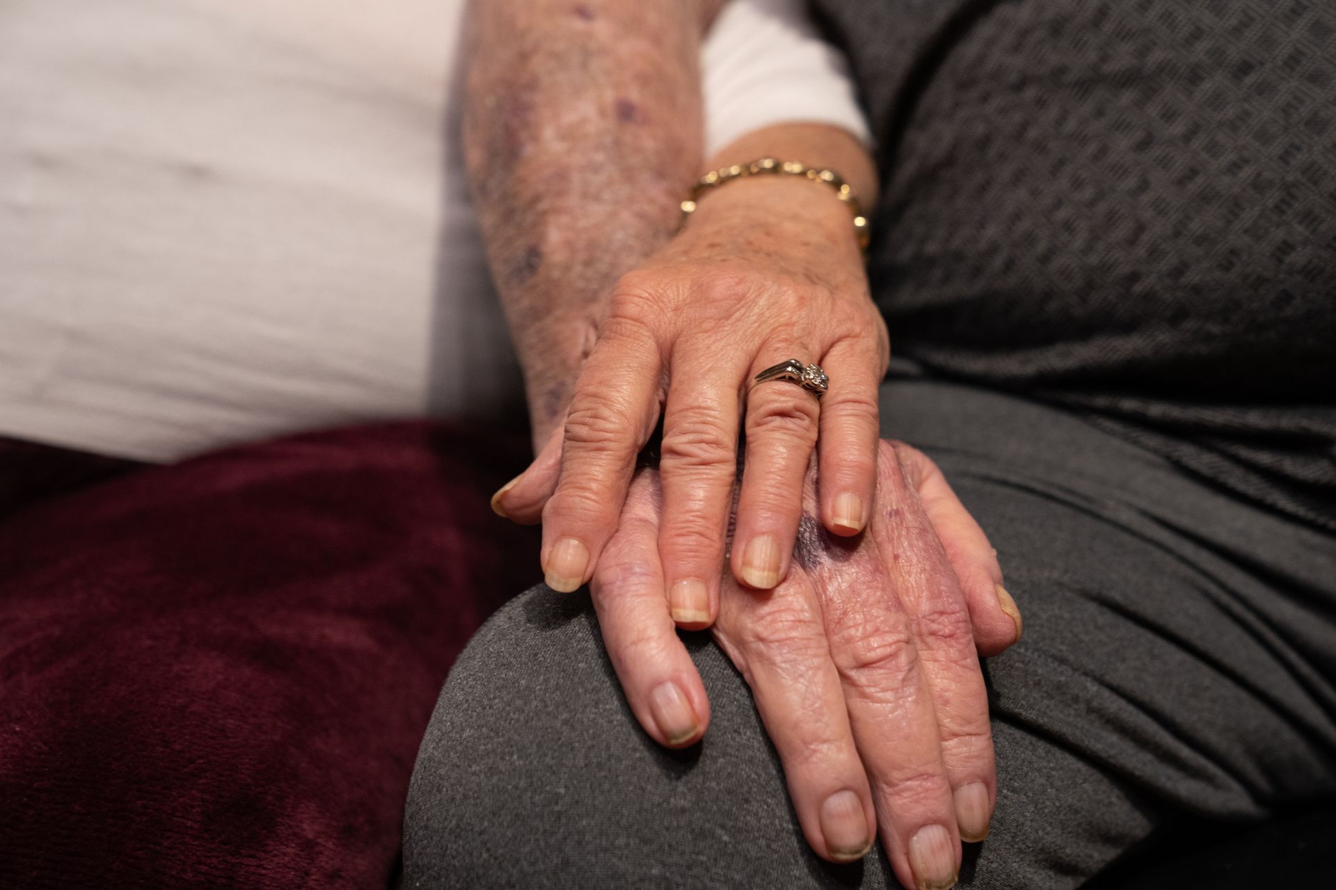A man and a woman are holding hands with rings on their fingers.
