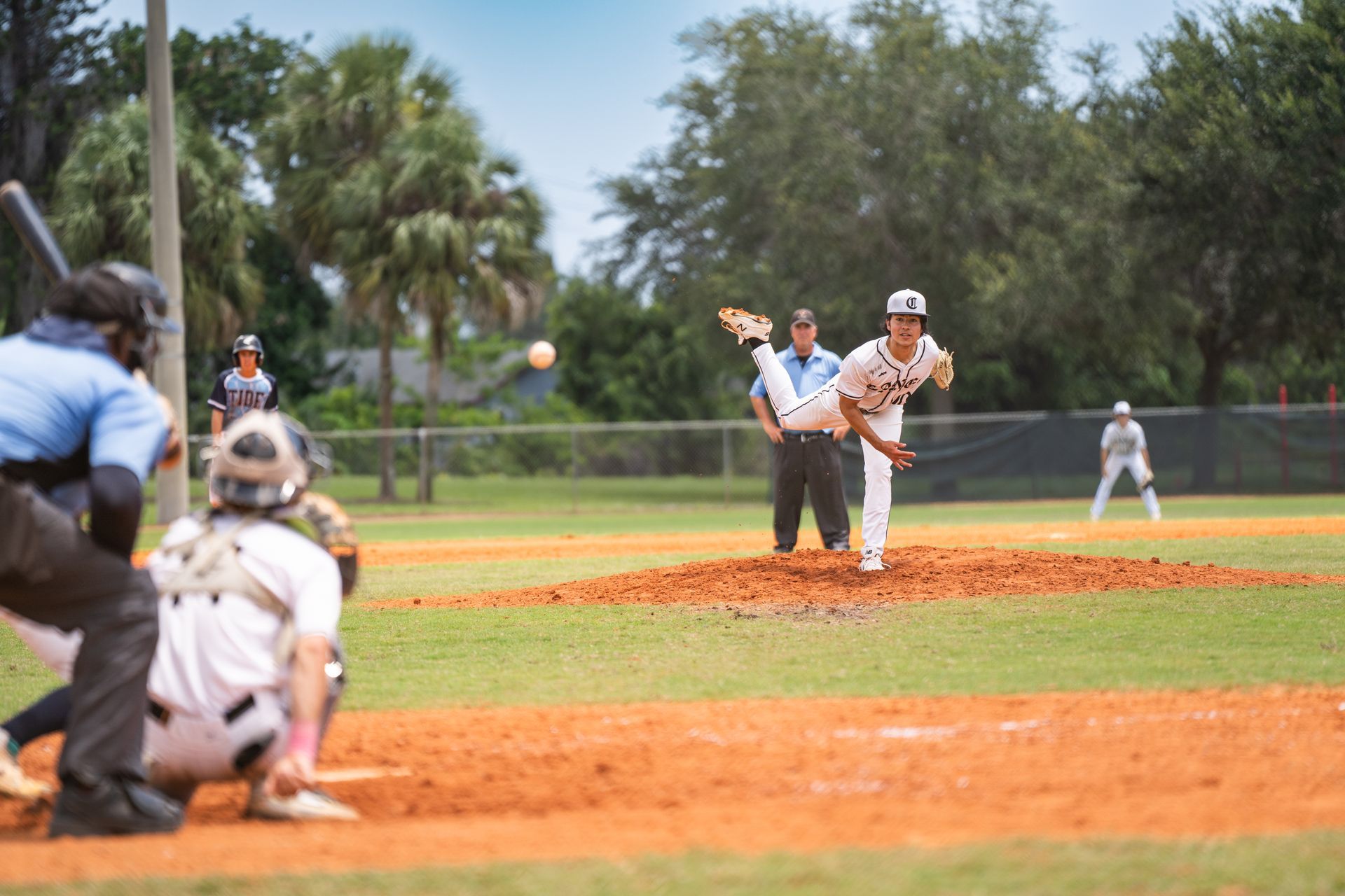 A baseball player is pitching a ball to a batter on a baseball field.