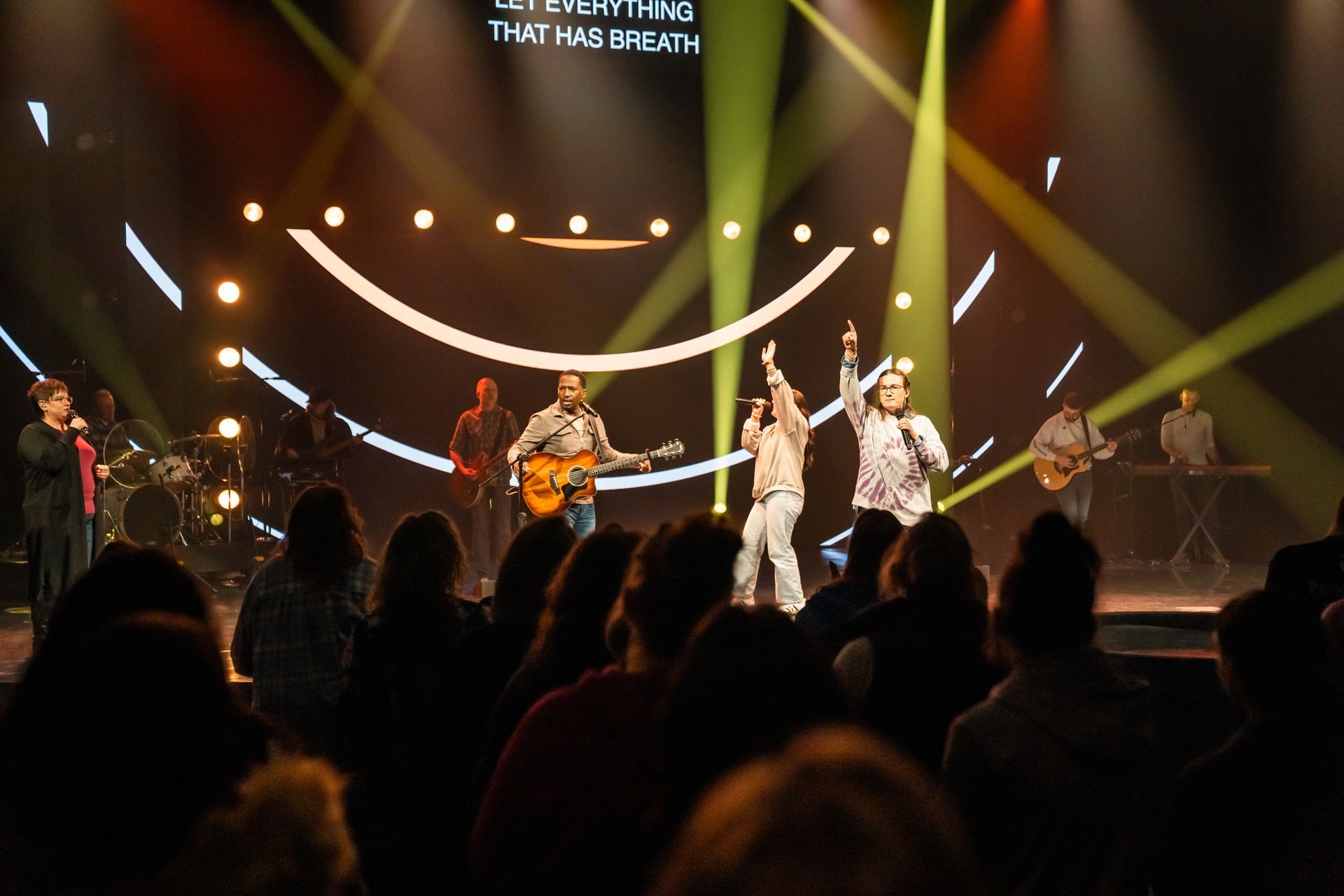 A group of people are playing instruments on a stage in front of a crowd.