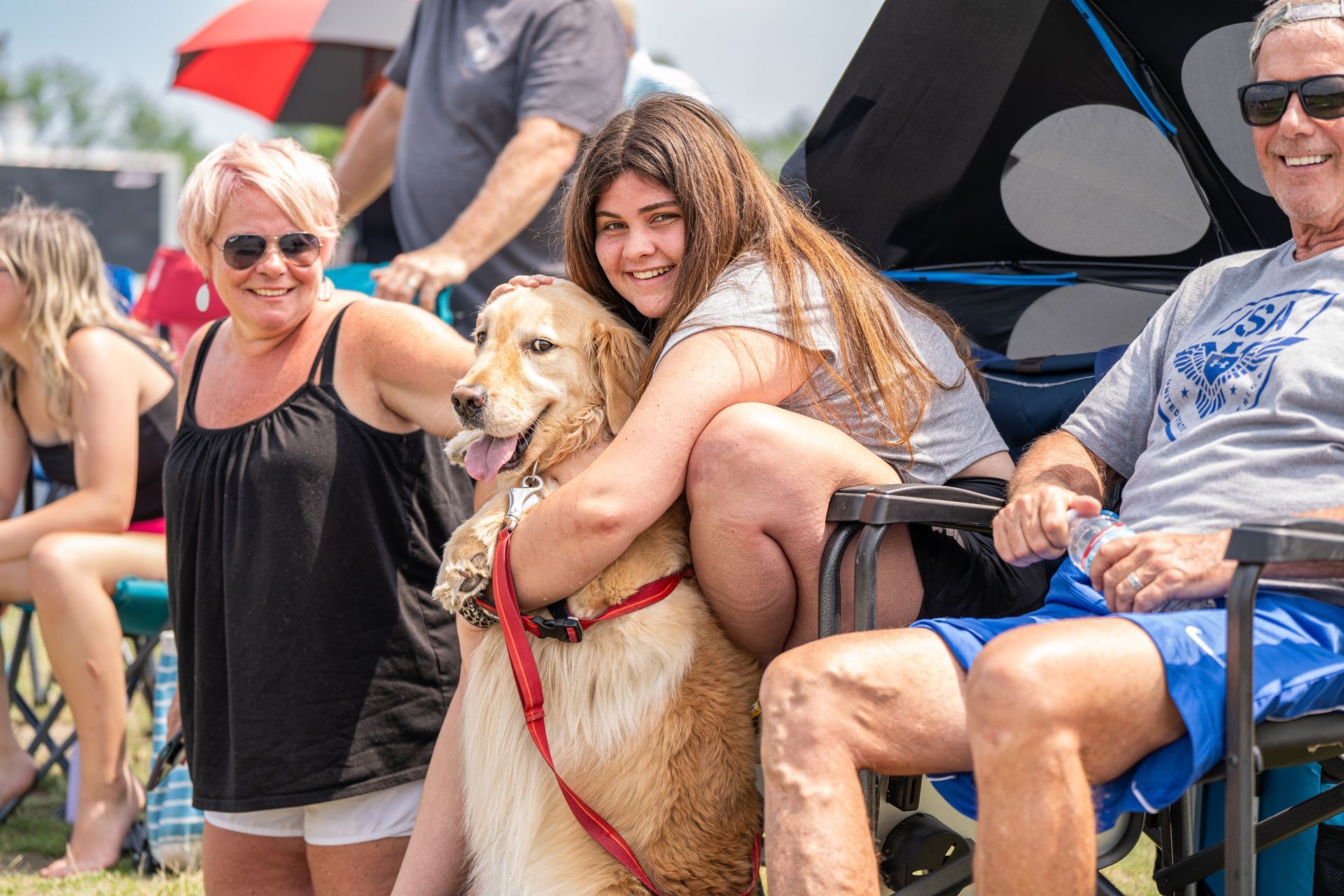 A group of people are sitting in chairs with a dog.
