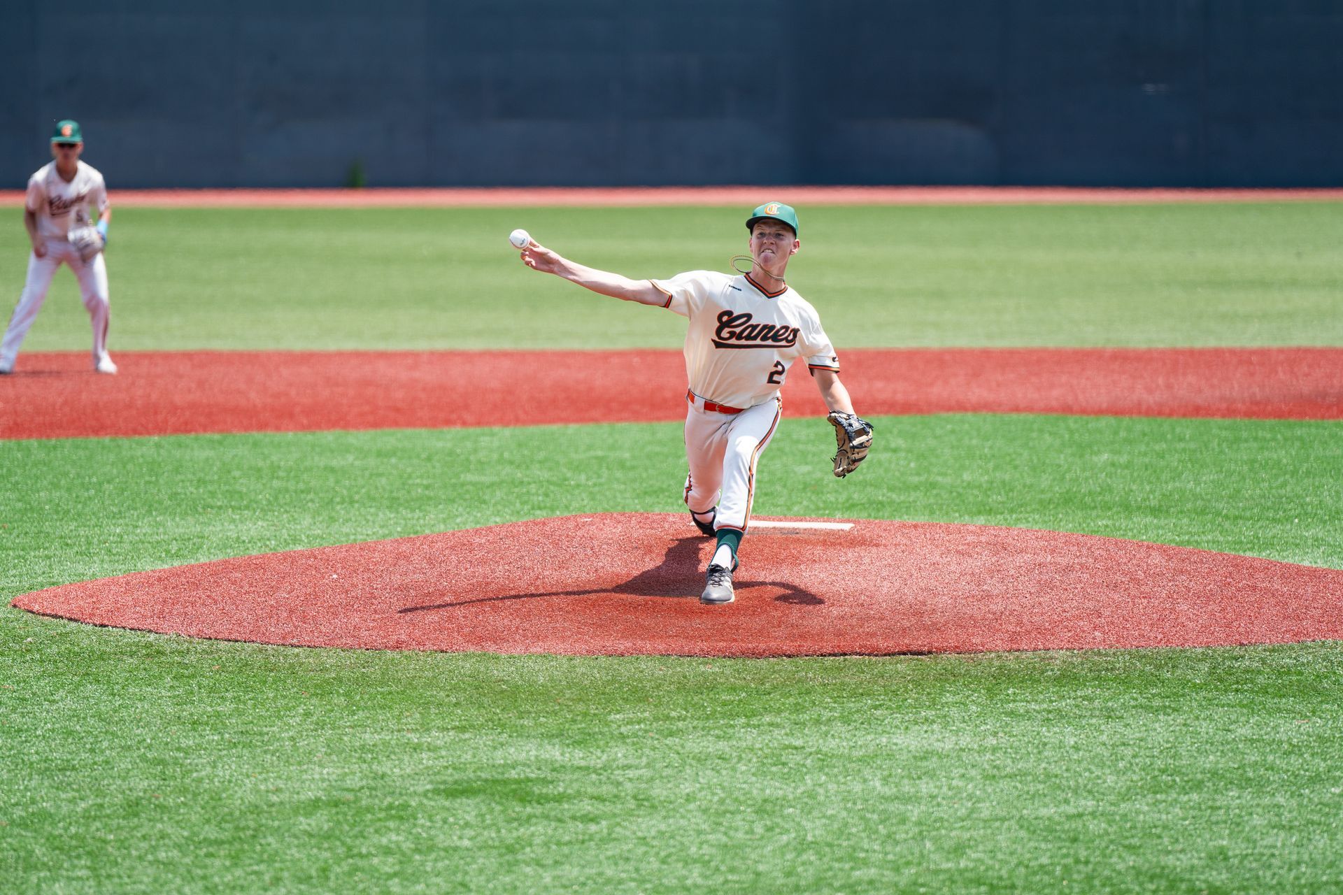 A pitcher is throwing a baseball on a baseball field.