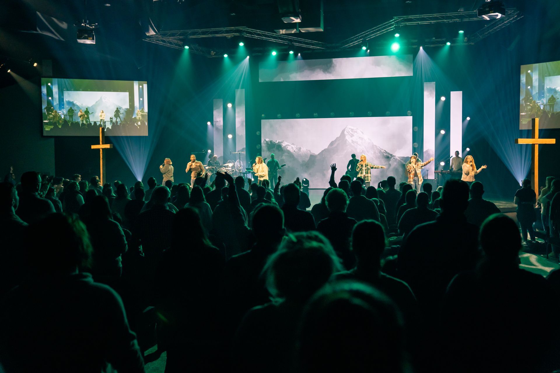 A group of people are standing in front of a stage in a church.