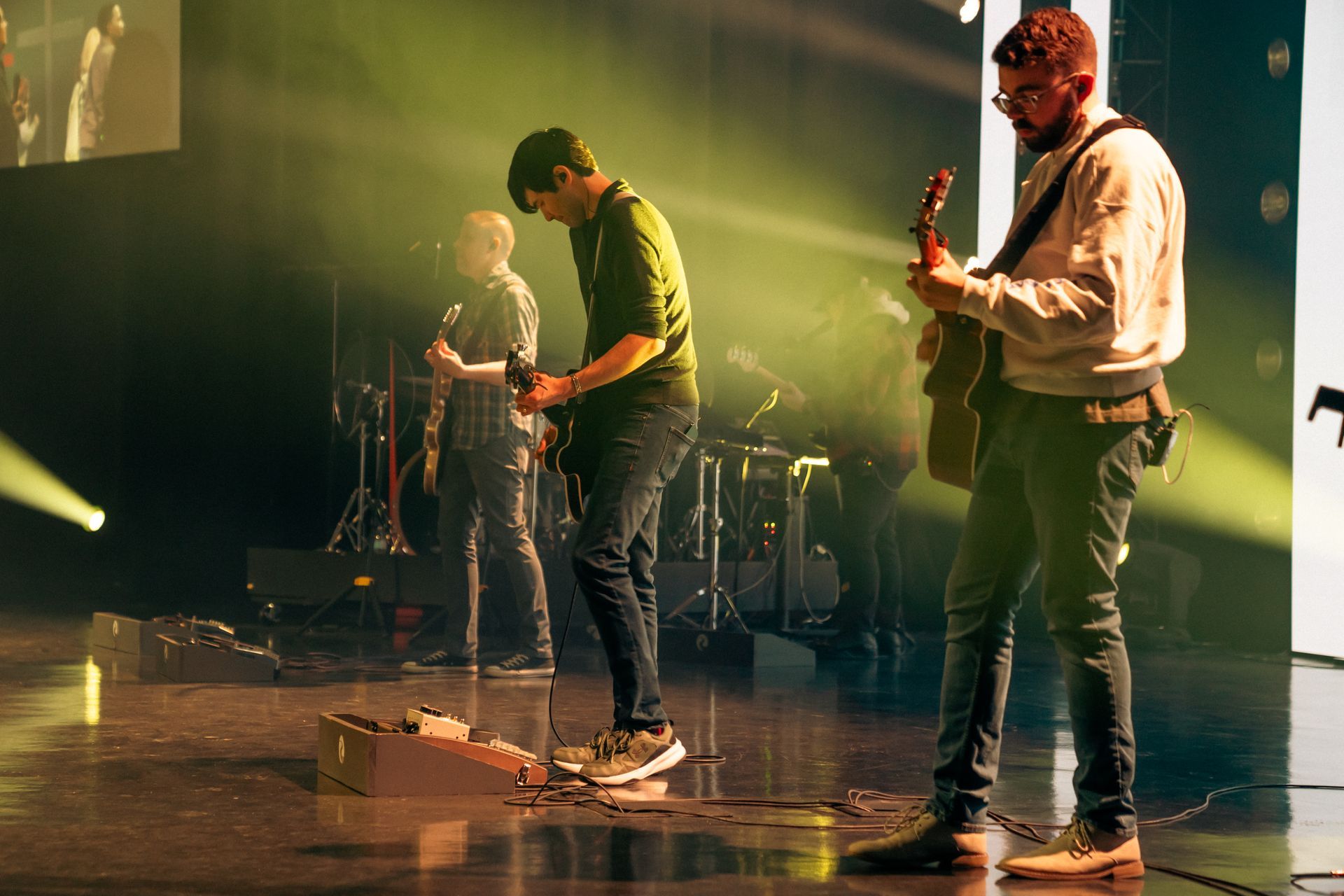 A group of men are playing guitars on a stage.