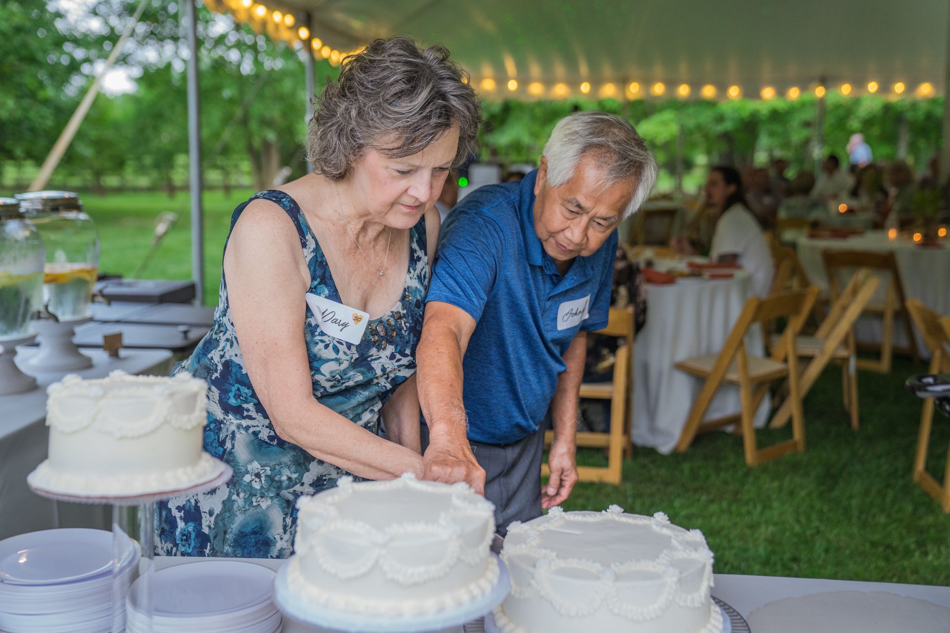 A man and a woman are cutting a wedding cake.