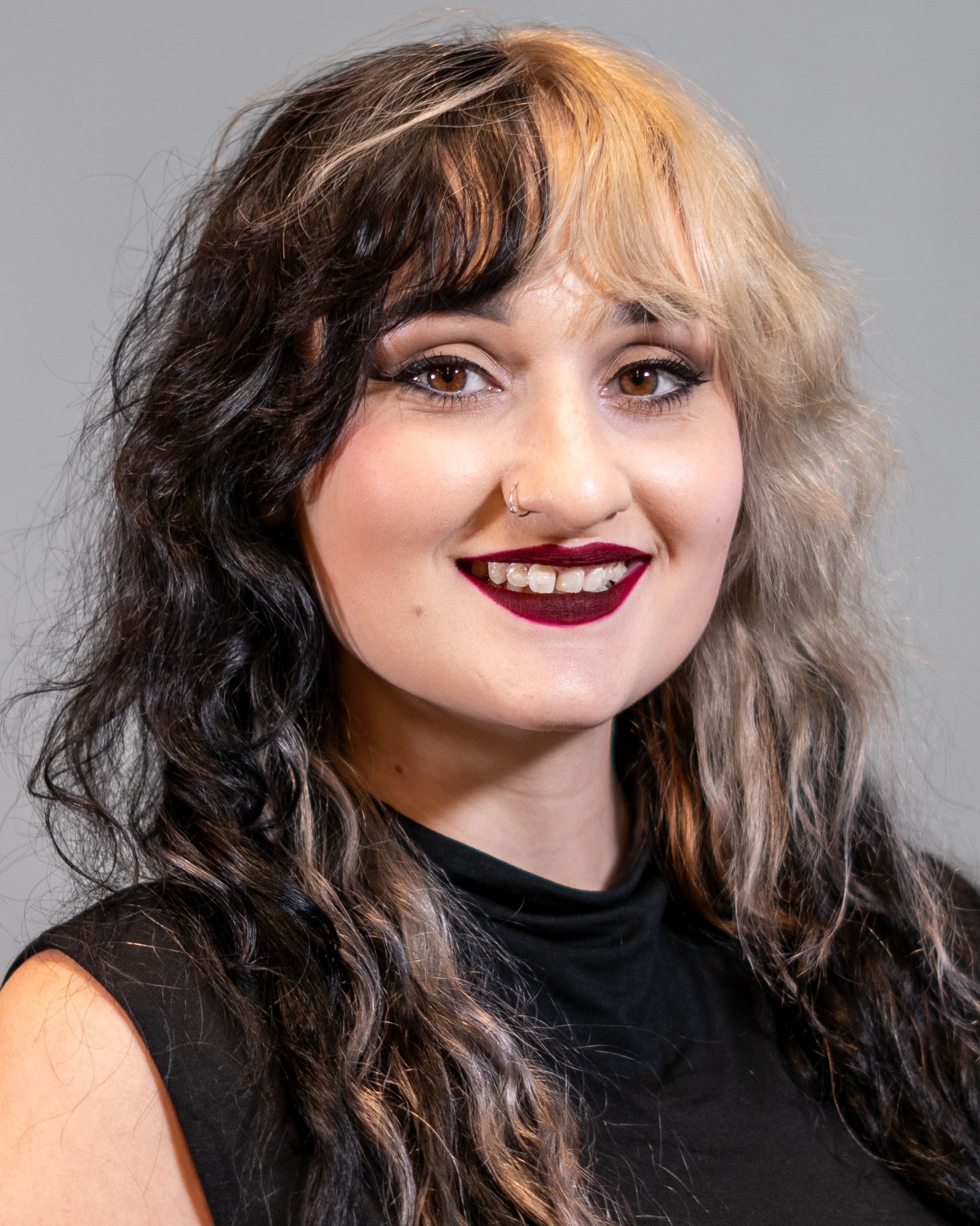 A woman with two different colored hair is smiling for the camera.