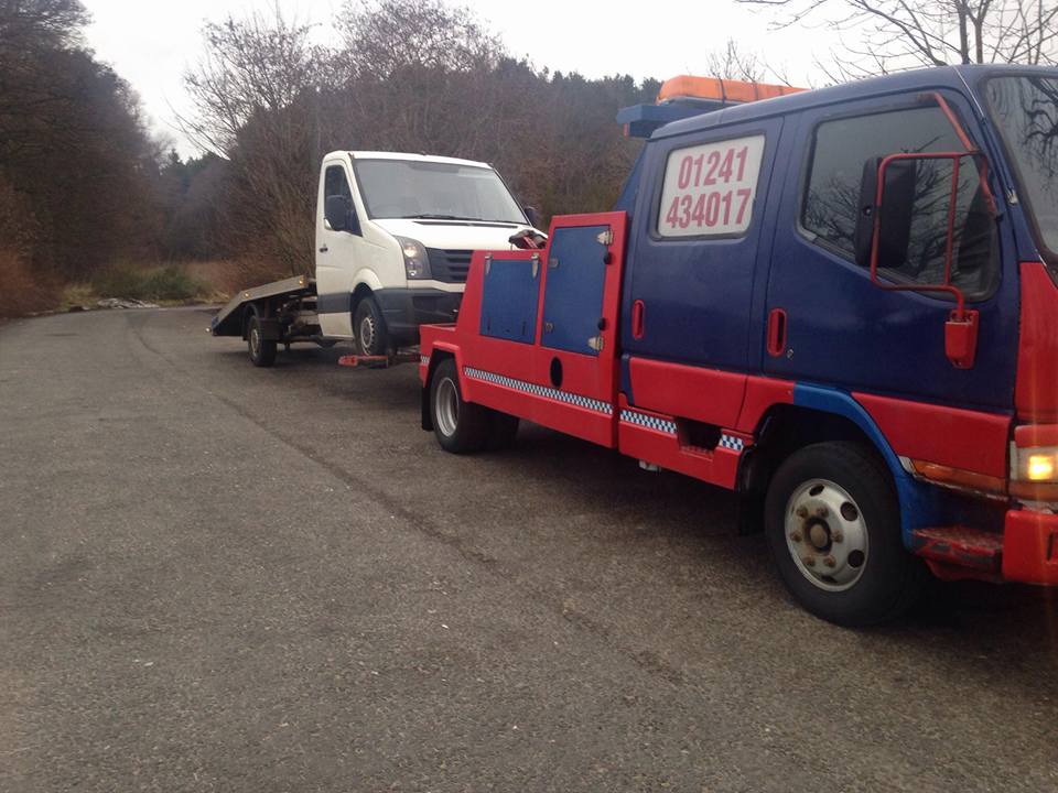 truck being pulled by a tow vehicle