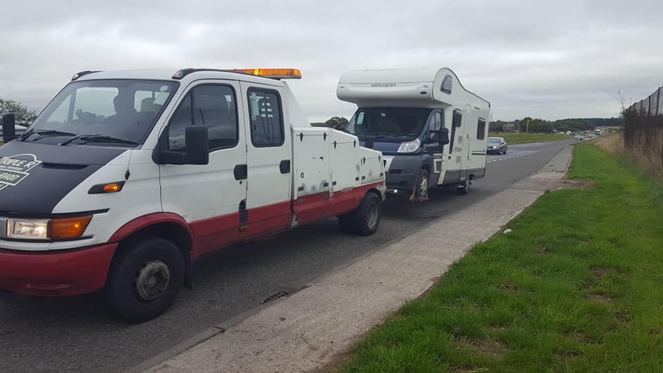 recovery truck pulling a trailer