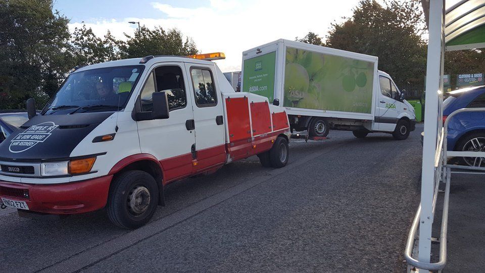 mini truck being pulled by a recovery truck