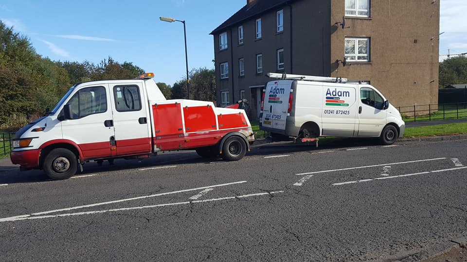 mini van being pulled by a recovery truck