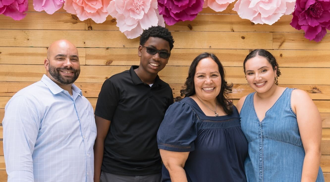Family posing in front of a wooden backdrop with 