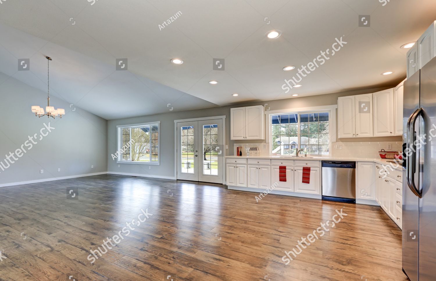 An empty kitchen in a new home with hardwood floors and stainless steel appliances.