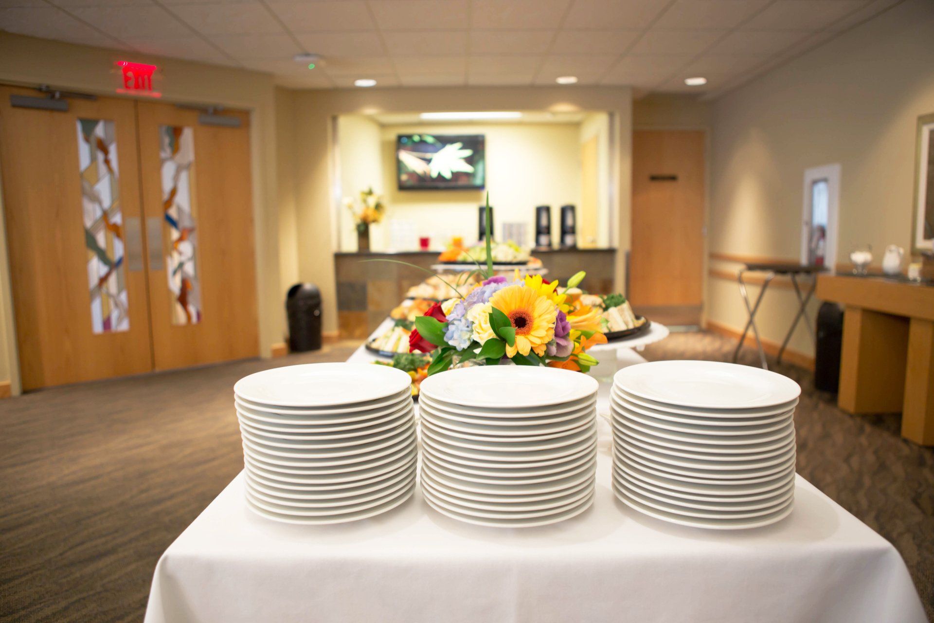 Table set with plates and cutlery, with the entrance to the Park Memorial Reception Center lounge in the background