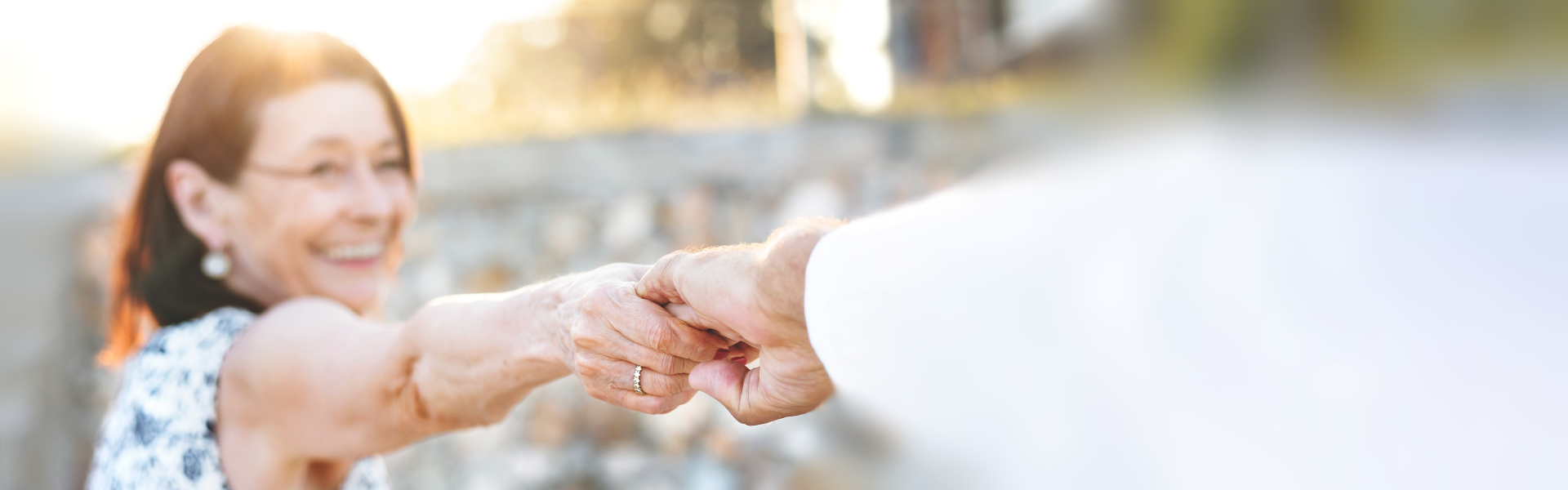 Happy lady holding hands with her husband at sunset - Park Memorial pre-planning solutions