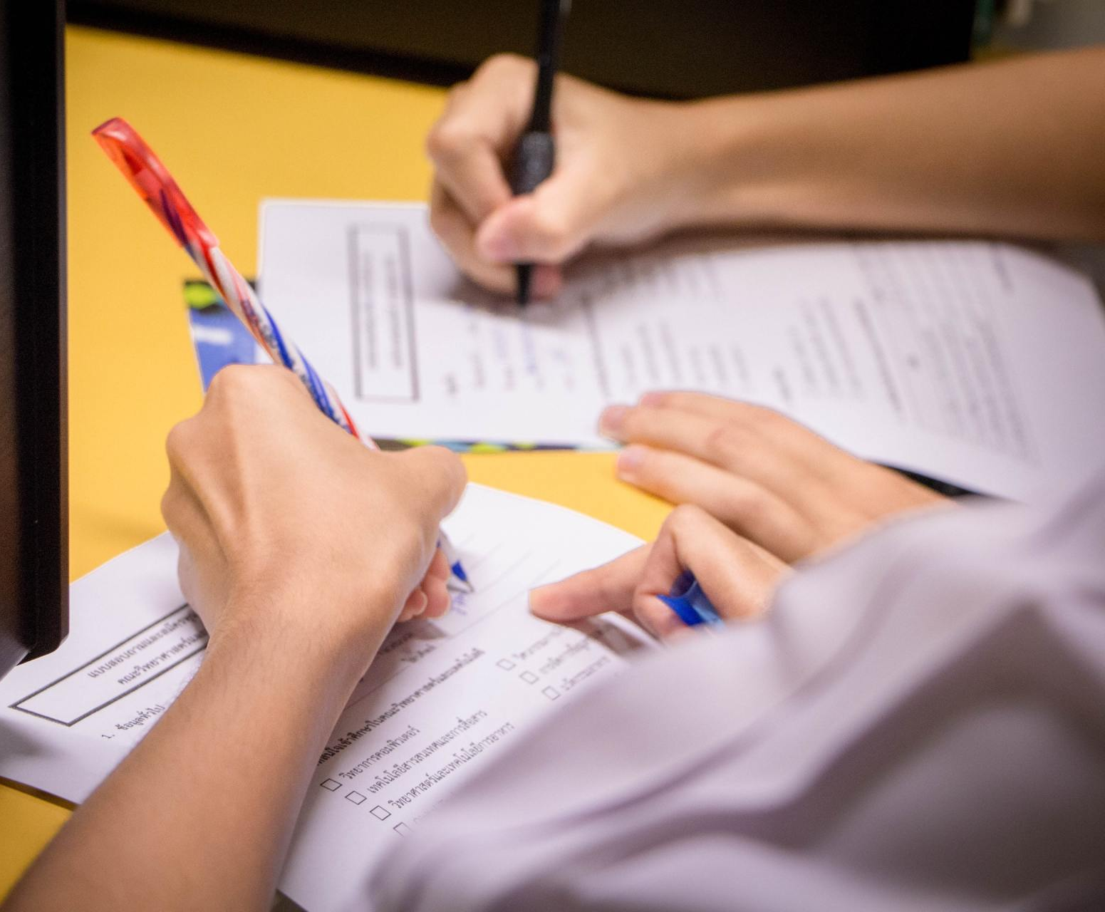 Two people helping each other and filling out documentation simultaneously - Assistance with end of life documents