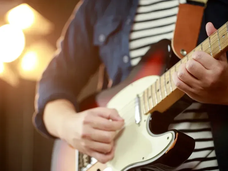 Image of a person on an electric guitar.