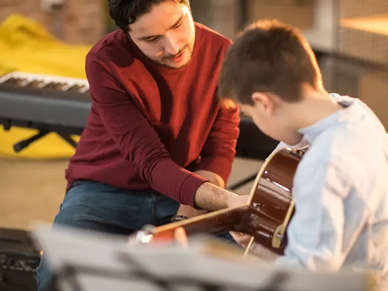 Image of a child learning guitar.