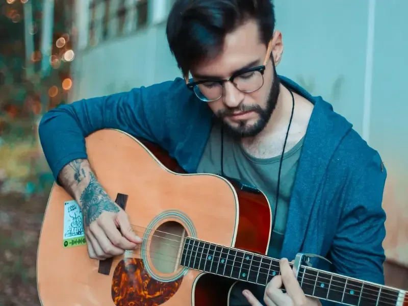 Image of a person developing musical skills because of guitar training.