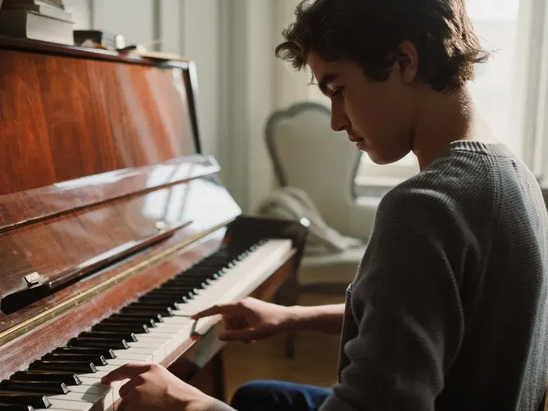 Image of a person on a piano keyboard.