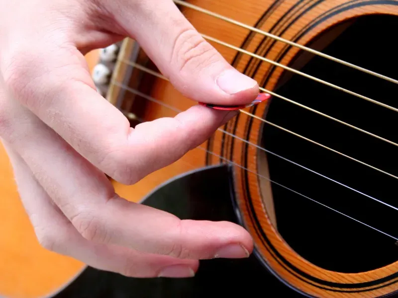 Image of a strumming guitar.