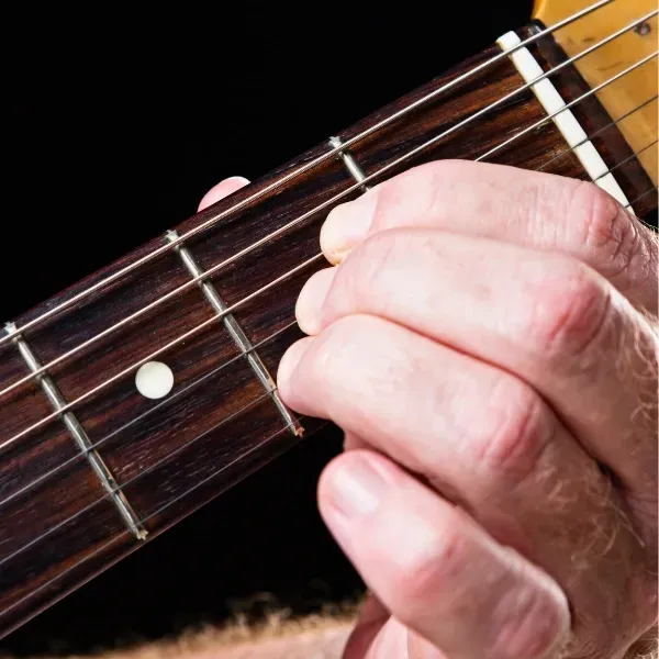 Image of fingers on guitar chords.