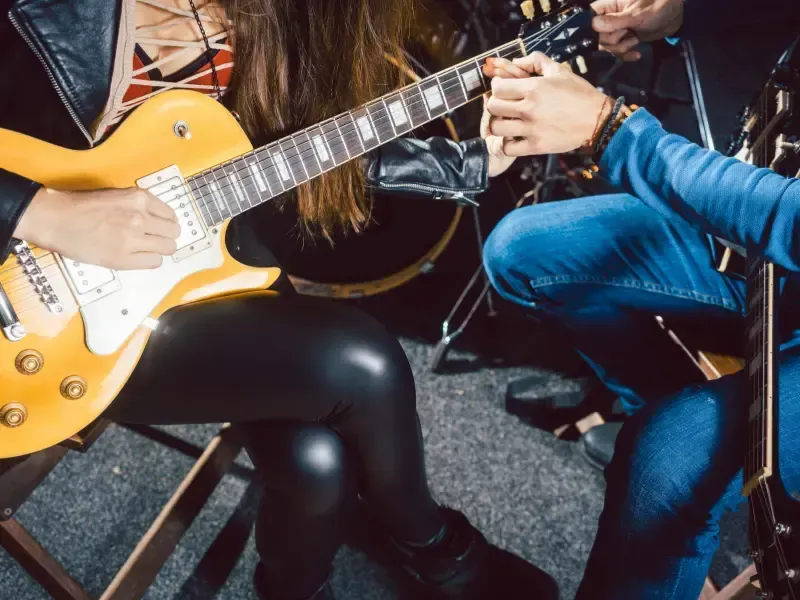 Image of people having fun learning guitar lessons.