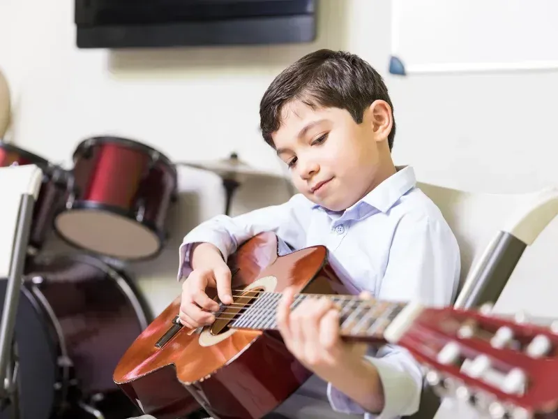 Image of a young guitarist having fun practing chord changes.
