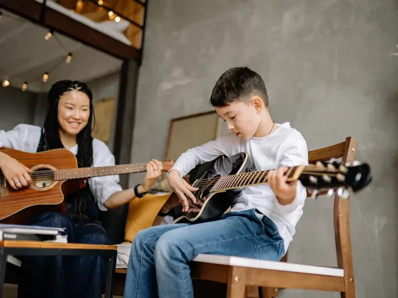 Image showing a person playing Here Comes the Sun chords on guitar.