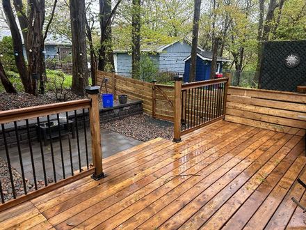 deck in a backyard with trees and a shed closeby