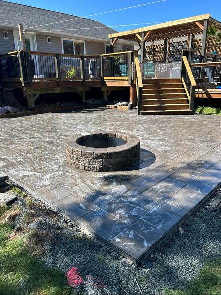fire pit on a patio with a deck in the background