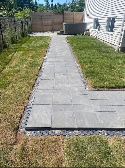 walkway beside a house with grass around it