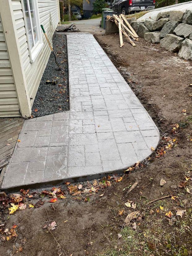 walkway running beside a house with gravel around it