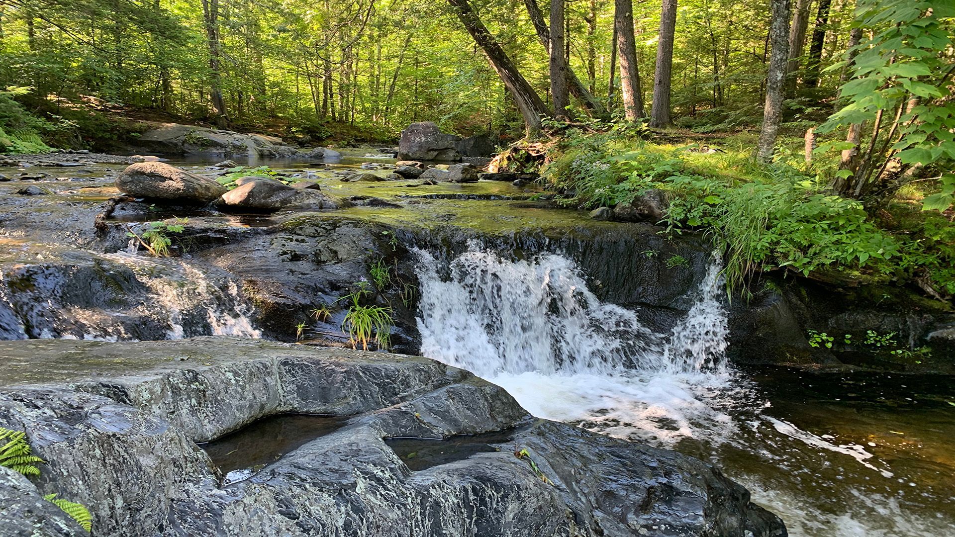The sun is setting over the ocean and the waves are crashing on the beach.