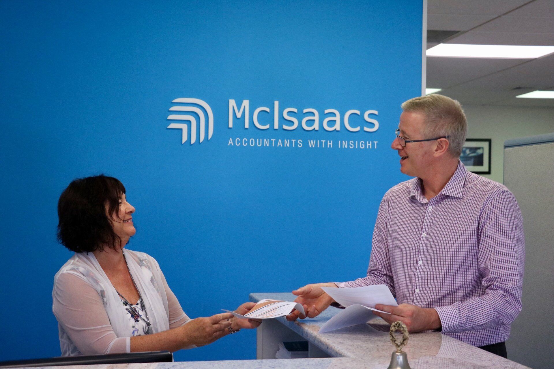 woman giving papers to an adult man