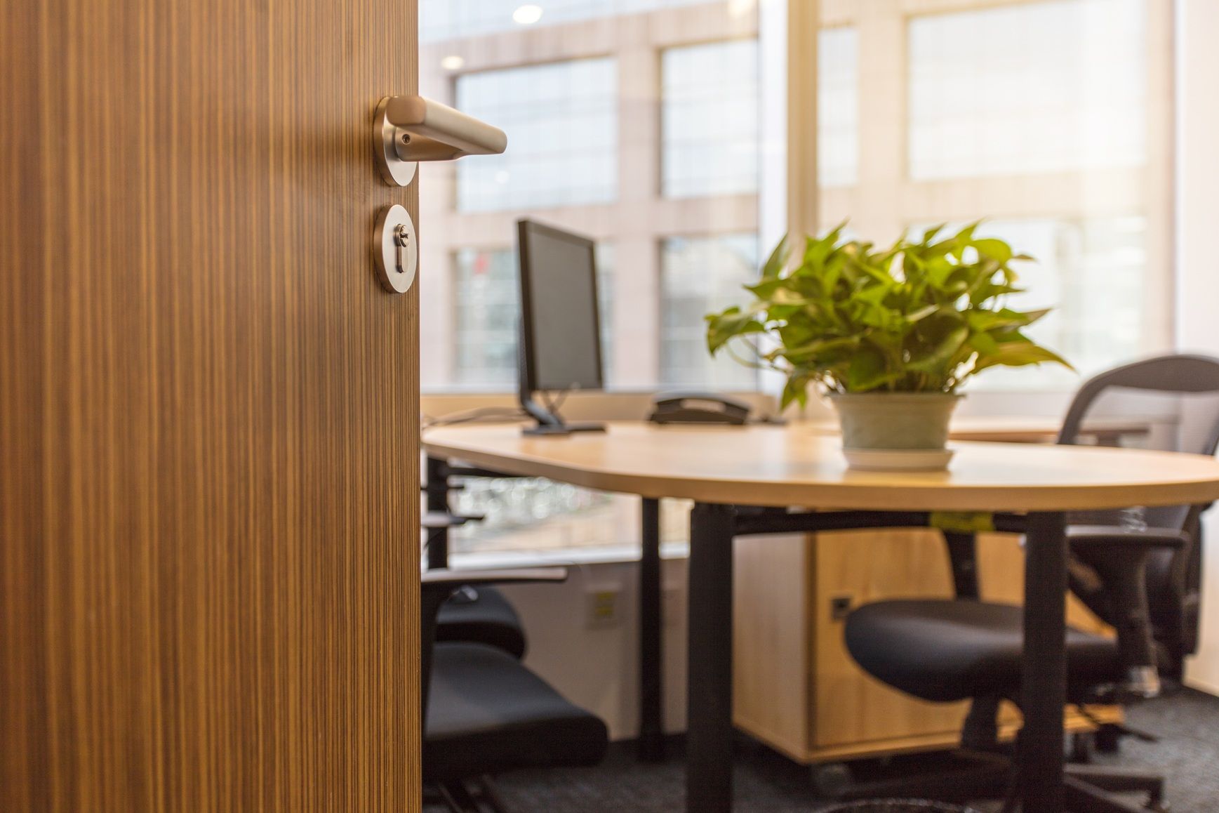 Une porte en bois est ouverte sur un bureau avec un bureau et une chaise.