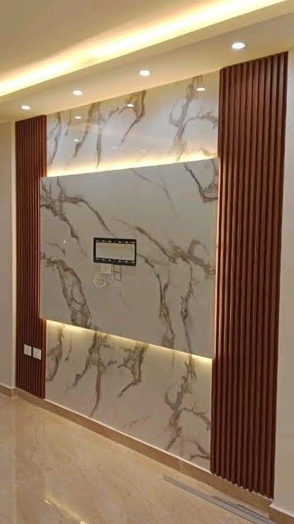 Close-up view of a stone wall composed of rectangular blocks in various shades of tan, brown, purple, and gray.