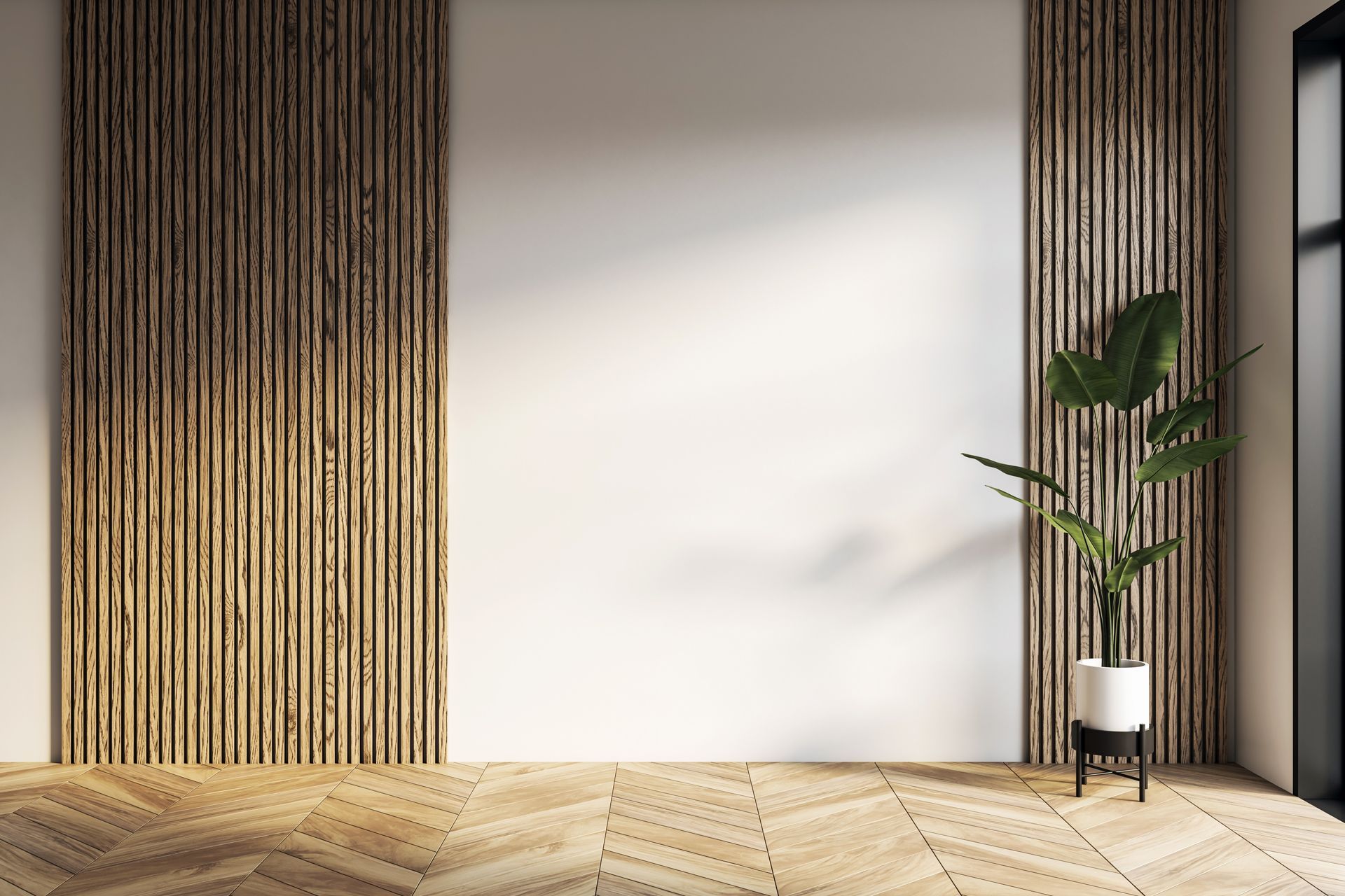 Empty room with wood paneling accents, white wall, potted plant, and wood floor.
