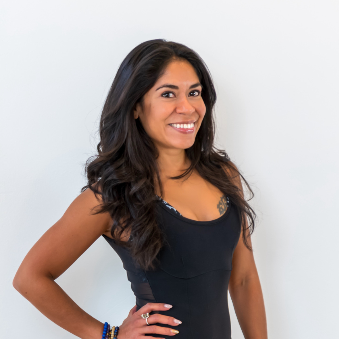 A woman in a black tank top smiles for the camera