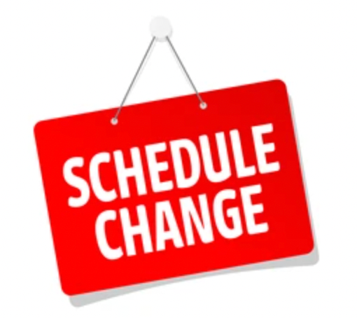 A woman in a floral dress is standing in front of a tree.