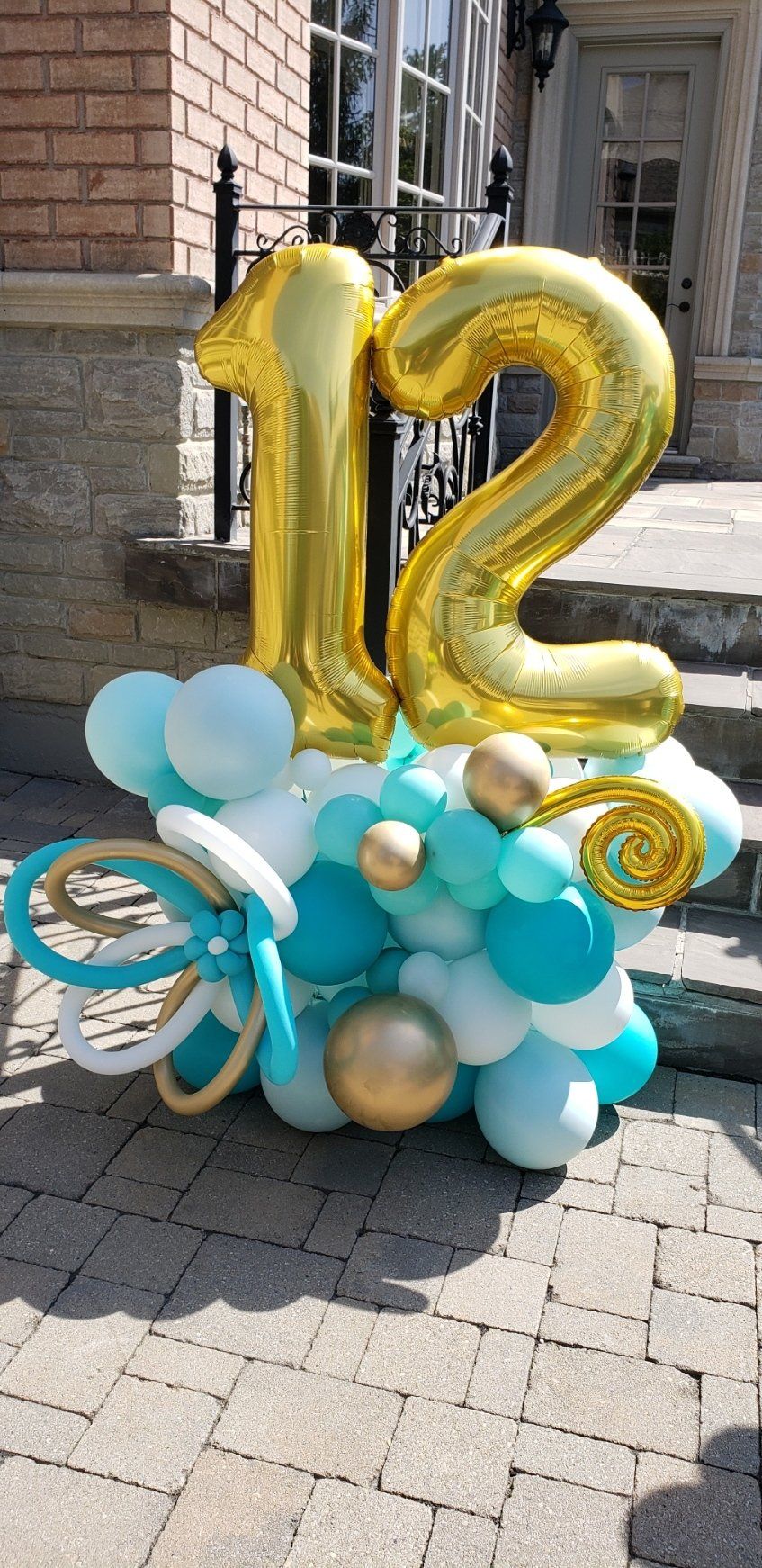 A bunch of balloons with the number 12 on top of them.