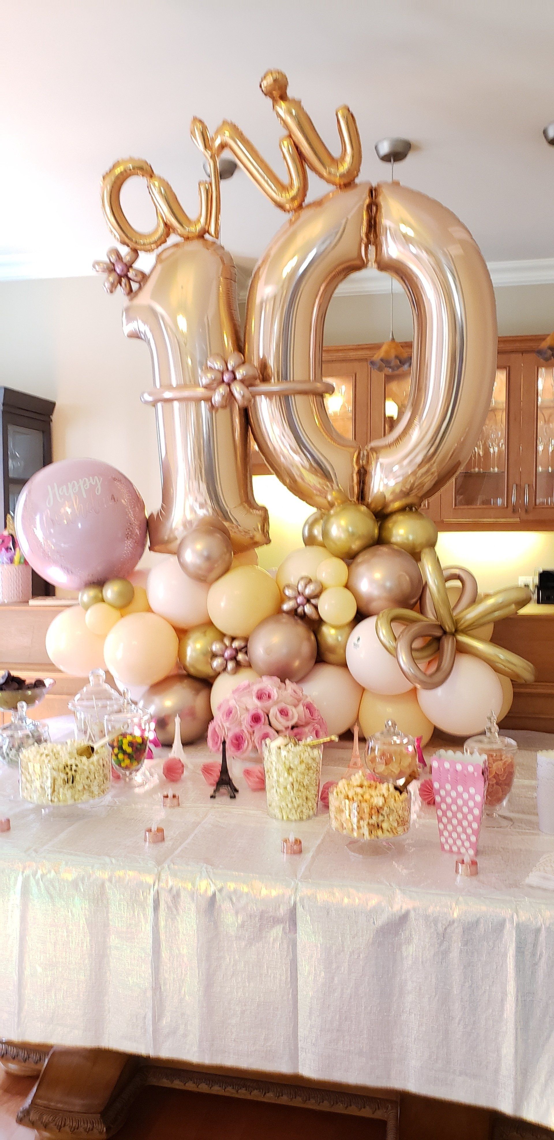 A table topped with balloons and flowers for a birthday party.