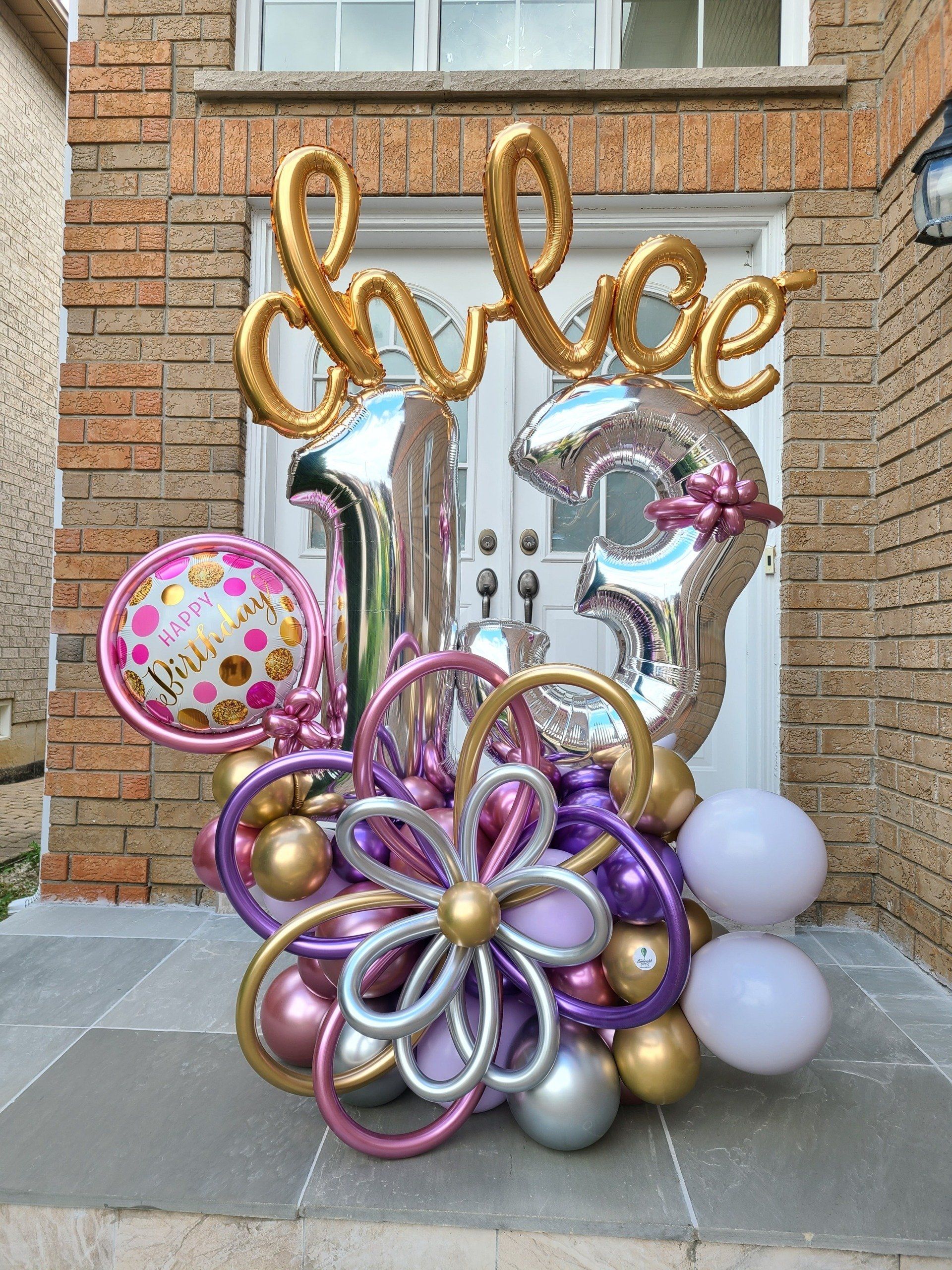A bunch of balloons are sitting in front of a brick building.