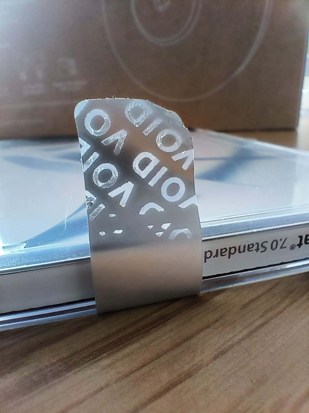 Close up of a silver 'void' tamper evident label that shows evidence of tampering