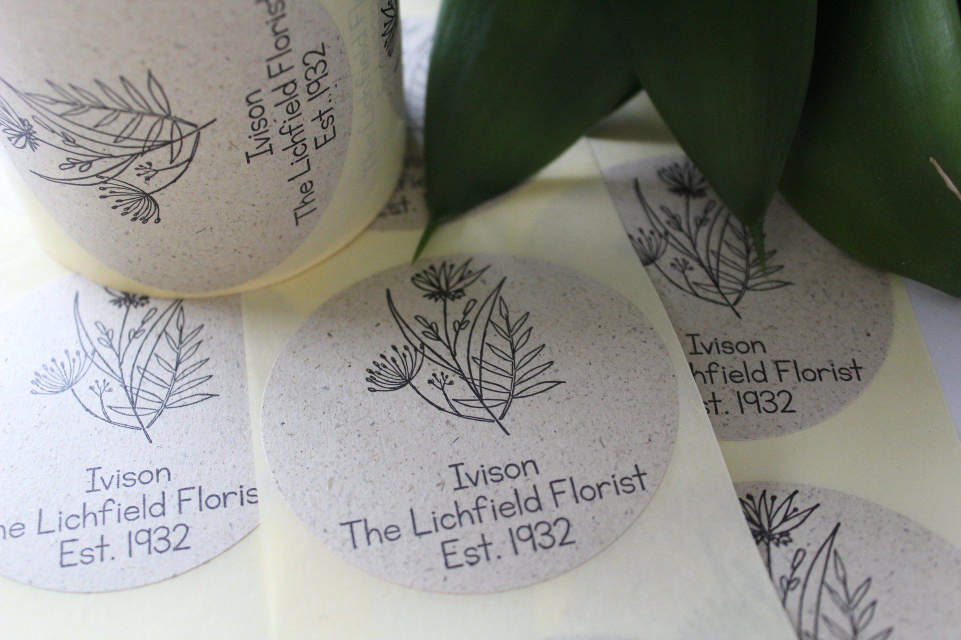A reel of labels with a black line drawing of flowers on them sitting on a table.