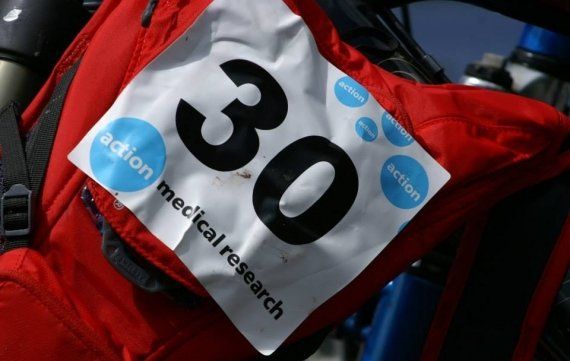 A large self-adhesive event label with the number 30 on it stuck to the back of red rucksack