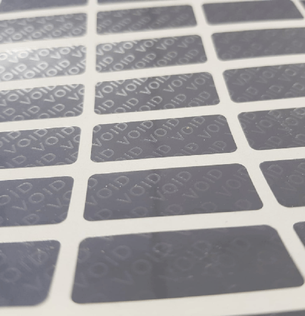 Close up of a sheet of silver 'void' tamper evident labels