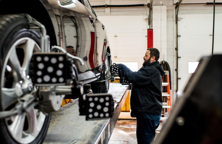 Mechanic inspecting a vehicle on a lift in an auto repair shop | Mears Automotive