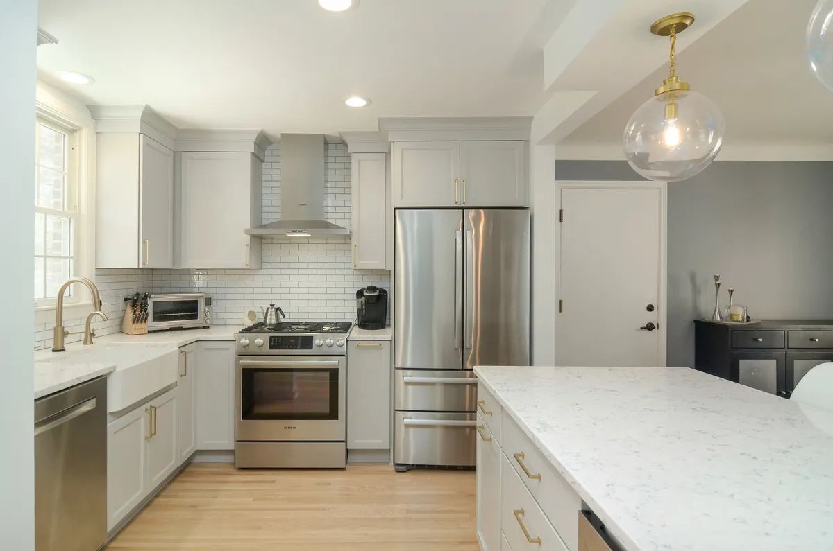 A kitchen with stainless steel appliances and white cabinets