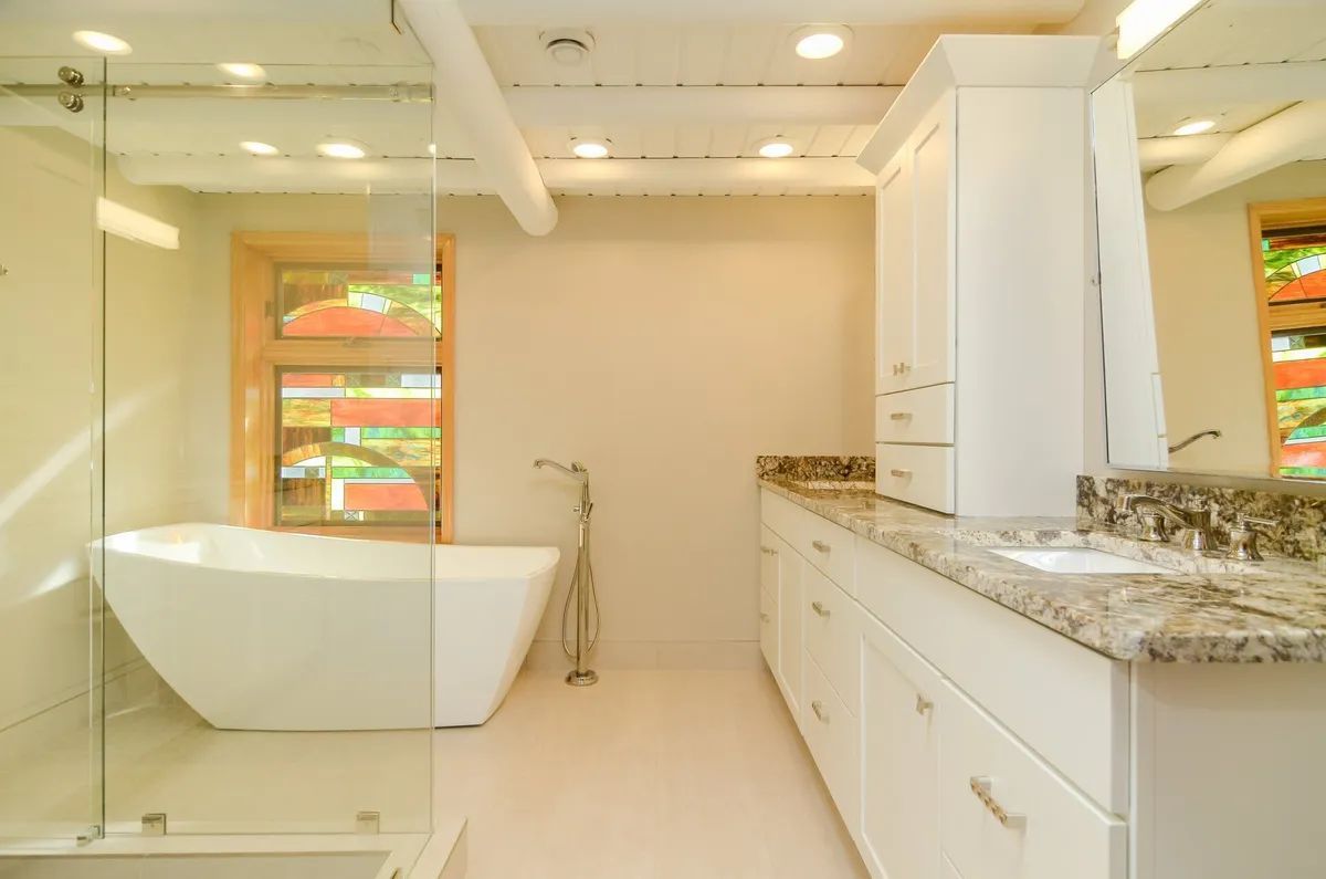 A bathroom with a bathtub , sink , and walk in shower.