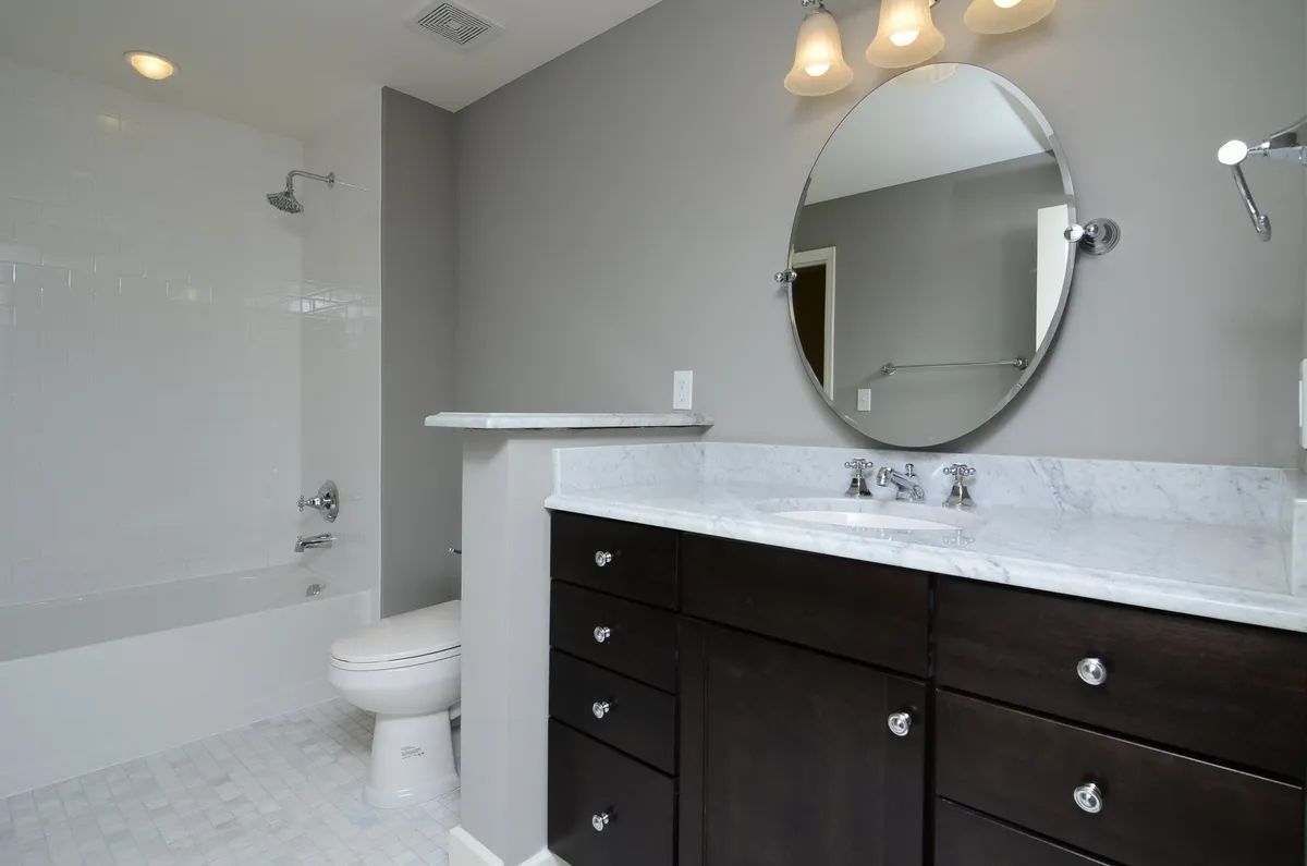 A bathroom with a toilet , sink , and mirror