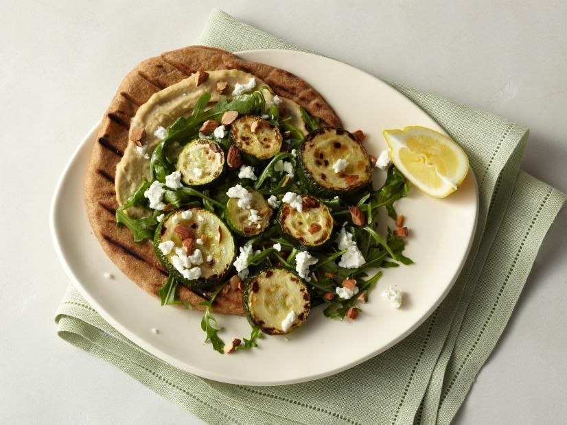 A white plate topped with a salad and pita bread